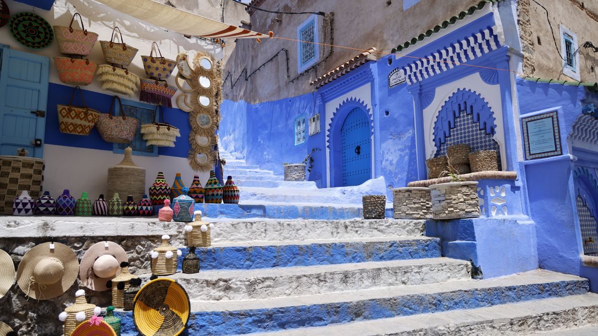 Borse e oggetti di artigianato in vendita su una scalinata blu della medina