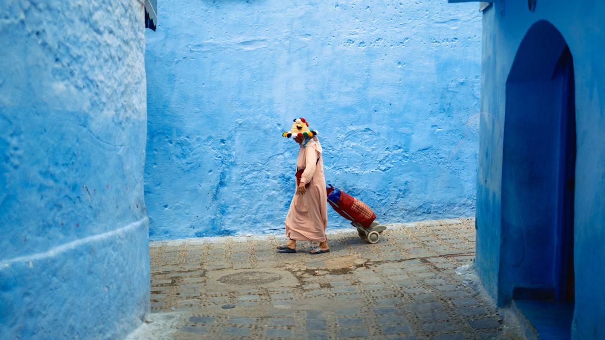 Una passante attraversa un vicolo blu di Chefchaouen
