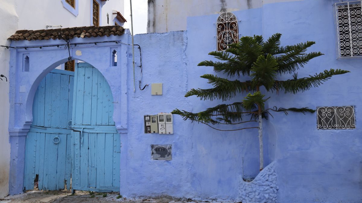 Porte blu ad arco su un muro azzurro nella medina di Chefchaouen