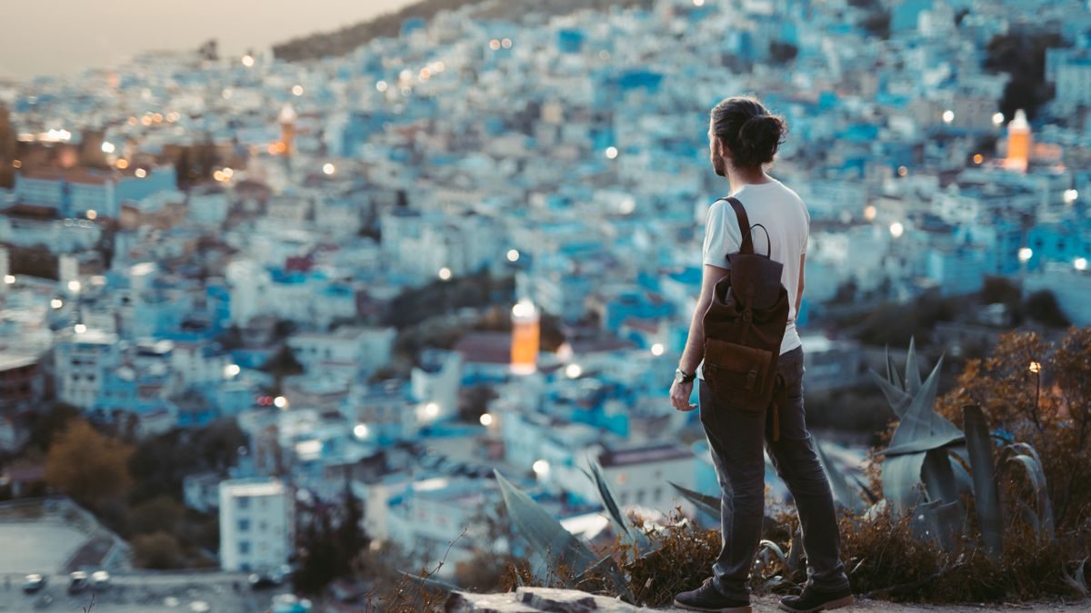 Un viaggiatore guarda Chefchaouen dall'alto al crepuscolo